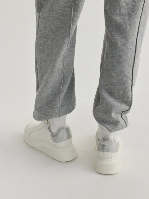 Gray sweatpants worn by a person on a white background