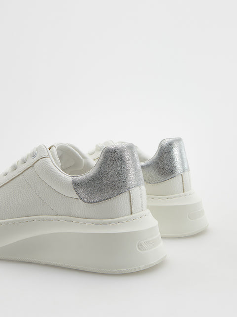 White sneakers with silver accents on a white background