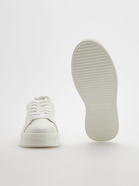 White sneaker with sole facing up on a white background