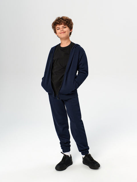 Person wearing a navy tracksuit on a white background
