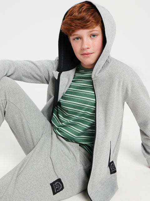 Young person wearing a gray hoodie with a brand logo on a white background