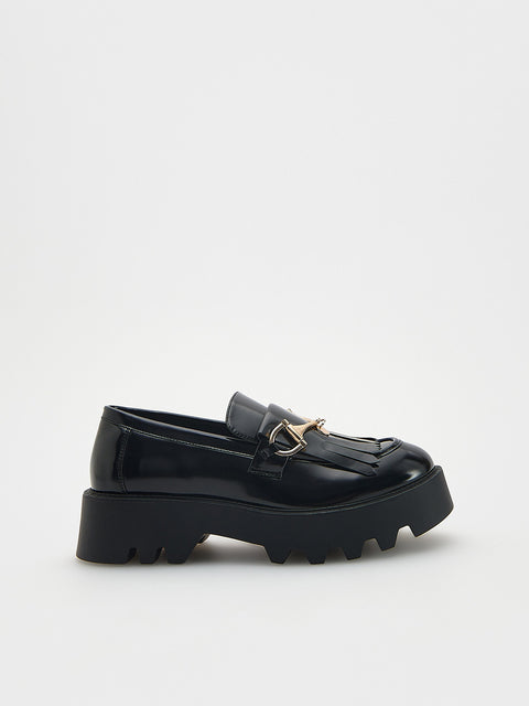 Black loafers with a gold buckle on a white background