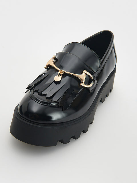 Black loafer with gold accents on a white background