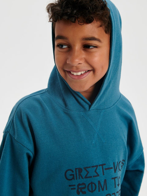 Child wearing a blue hoodie with text on a white background