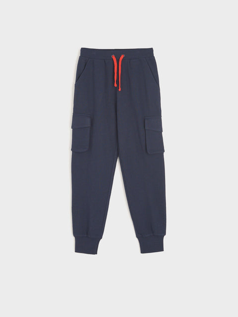 Navy blue cargo jogger pants with a red drawstring on a light gray background