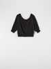 Black blouse with lace trim on a white background