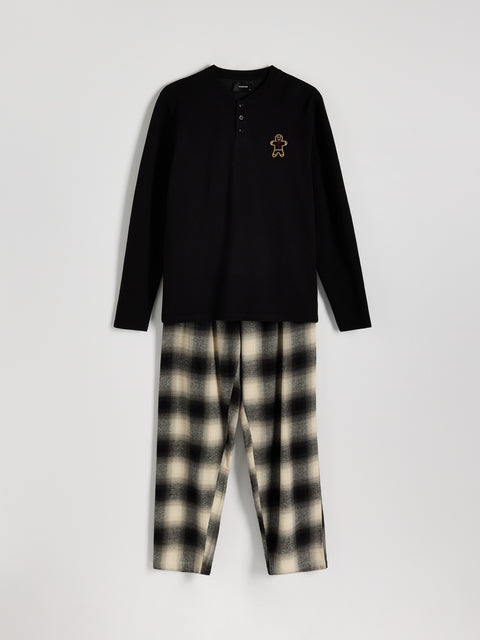 Black long-sleeve shirt and plaid pants set on a white background