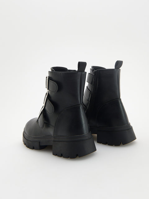 Black leather boots with chunky soles on a white background