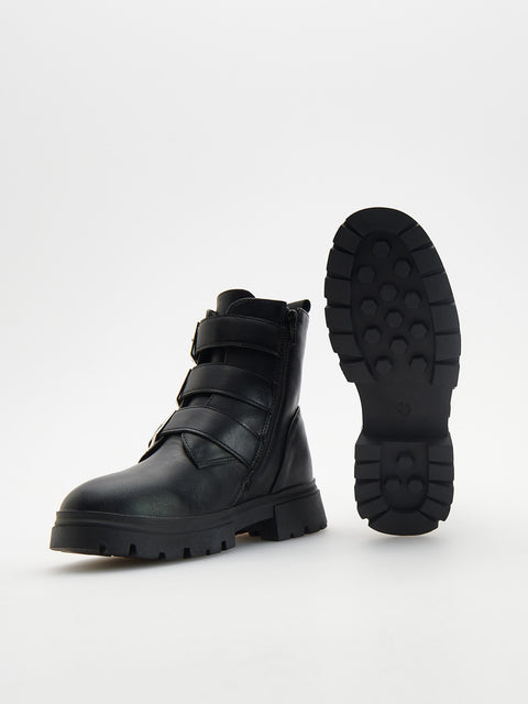 Black leather boot with strap details on a white background