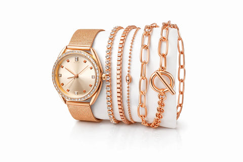 Rose gold watch and bracelets on a white surface
