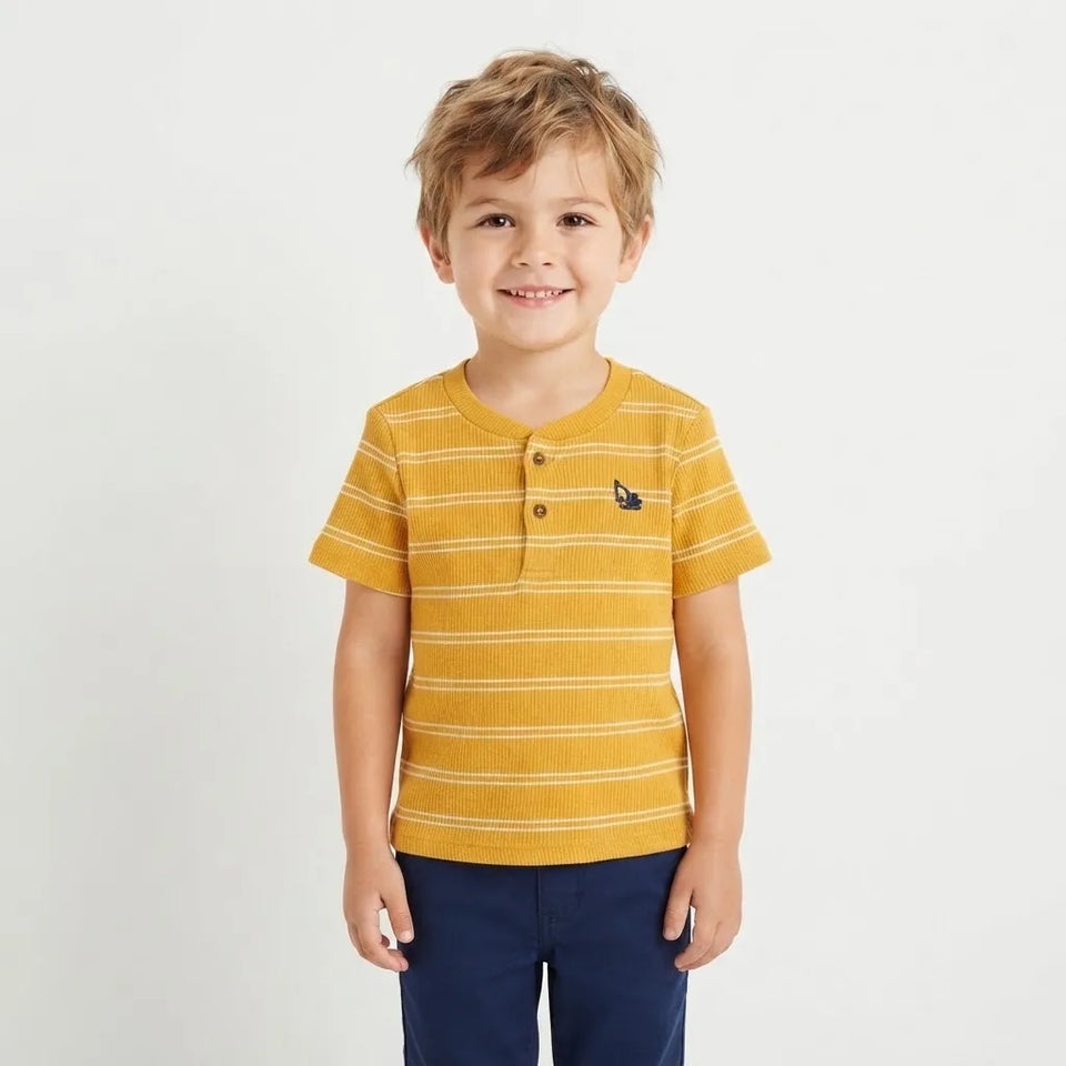 A young boy wearing a yellow and white striped short-sleeve henley shirt with a small navy logo on the chest, paired with navy pants, standing against a light gray background.