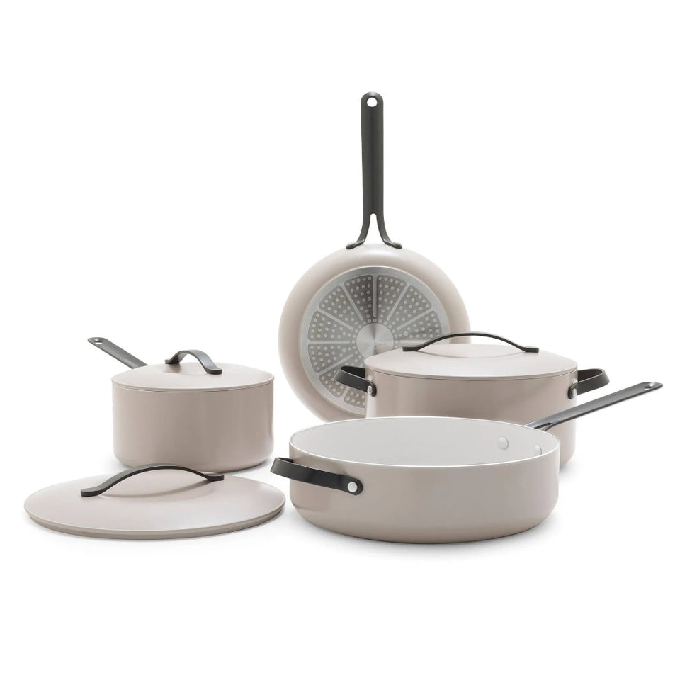 Set of beige cookware with black handles on a white background