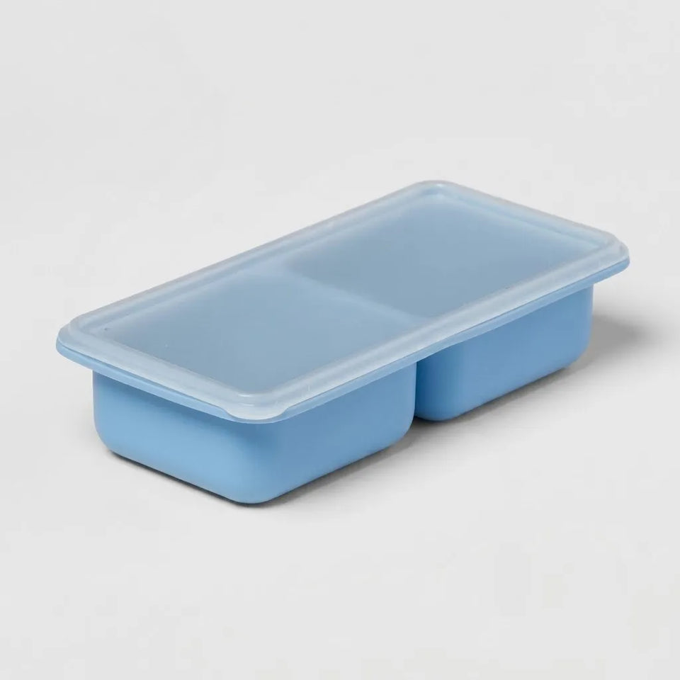 A light blue plastic food storage container with a matching translucent lid, featuring two compartments, shown on a clean white background.