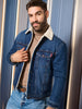 Man wearing a blue denim jacket with a white fur collar against a neutral background
