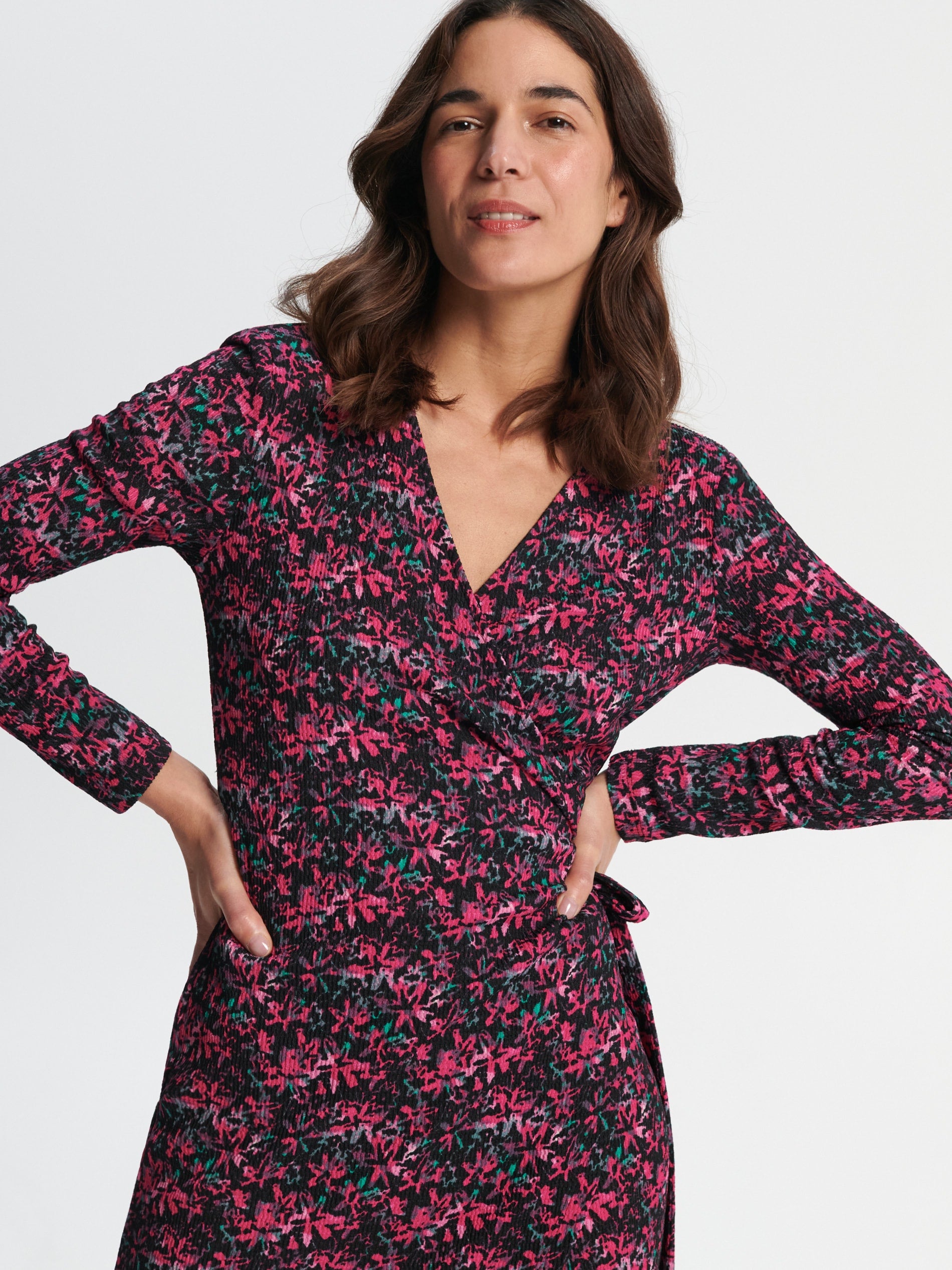 Woman wearing a floral dress with a plain background