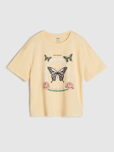 Yellow t-shirt with butterfly and flower design on a light gray background