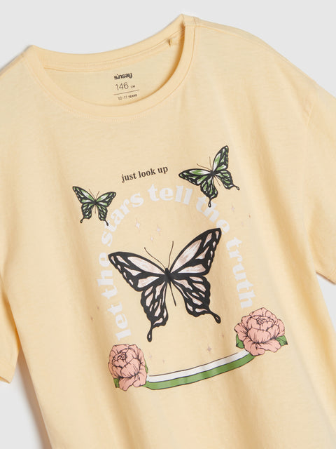 Yellow t-shirt with butterfly and floral design on a white background