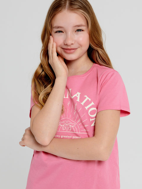 Young girl wearing a pink t-shirt with text on a plain background