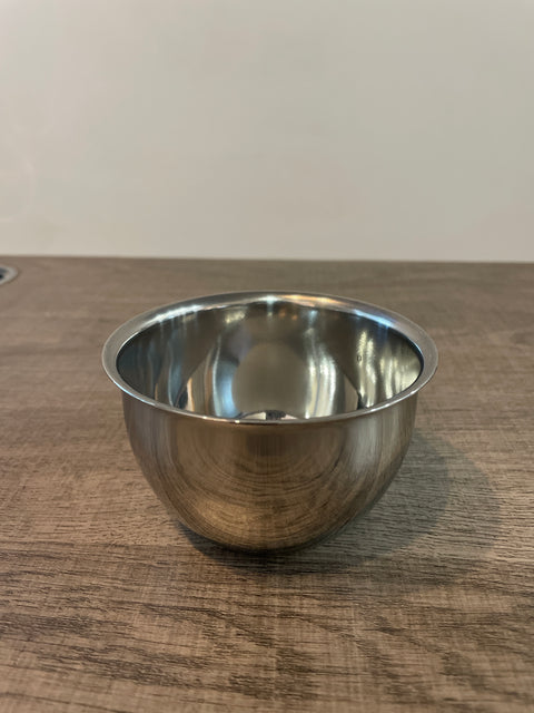 Stainless steel bowl on a wooden surface