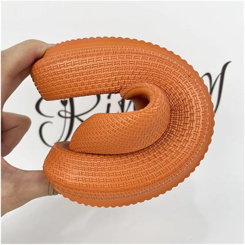 Orange textured object held by a hand against a blurred background