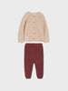 Beige cardigan and maroon pants set on a light beige background