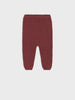 Maroon baby pants on a light gray background