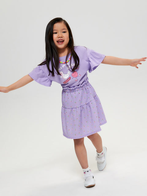 Young girl wearing a purple outfit with a white background