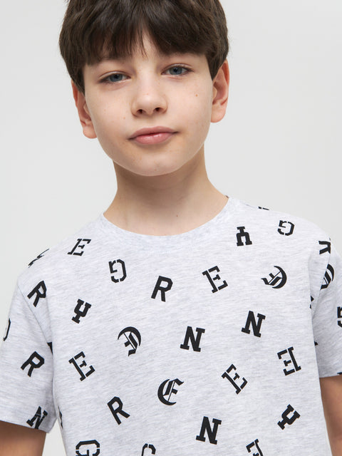 Child wearing a gray t-shirt with black letter pattern on a white background