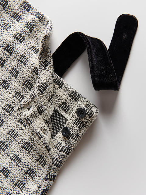 Black and white patterned fabric with a black ribbon on a light gray background