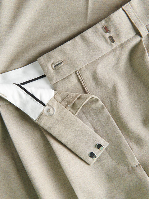 Close-up of beige pants with a belt and button details