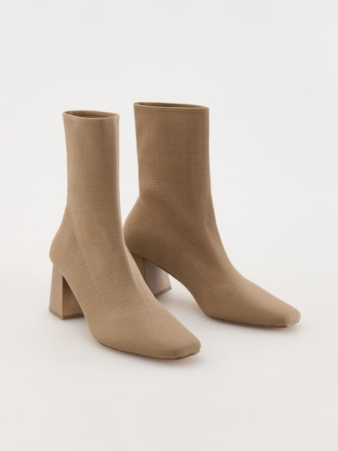 Pair of beige sock boots on a white background