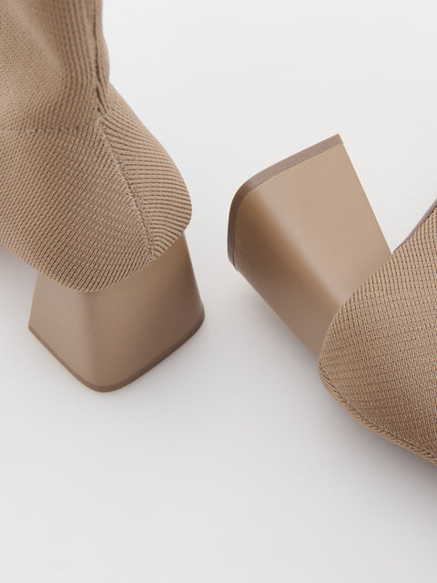 Close-up of beige sock boots on a white background