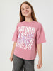 Young girl wearing a pink t-shirt with a graphic design on a white background