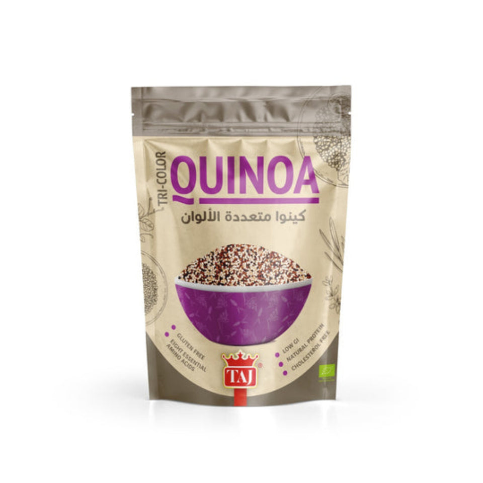 A package of Taj Tri-Color Quinoa featuring a bowl of quinoa with colors red, white, and blue, and a background that includes a mountain and text.