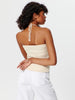 Woman wearing a beige strapless top with a lace detail on a white background