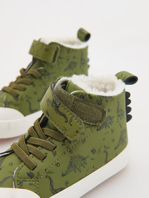 Green high-top sneakers with dinosaur pattern on a white background