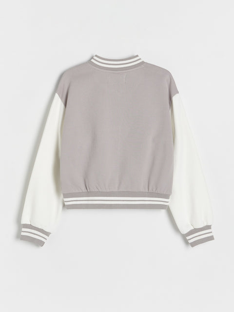 Gray and white sweatshirt with striped cuffs and hem on a light gray background