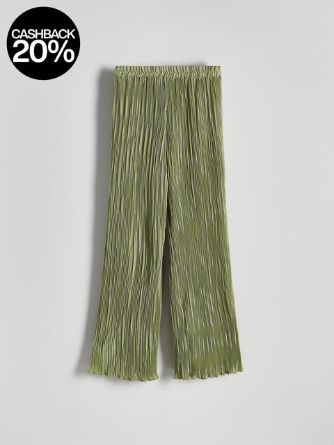 Green pleated pants on a light gray background