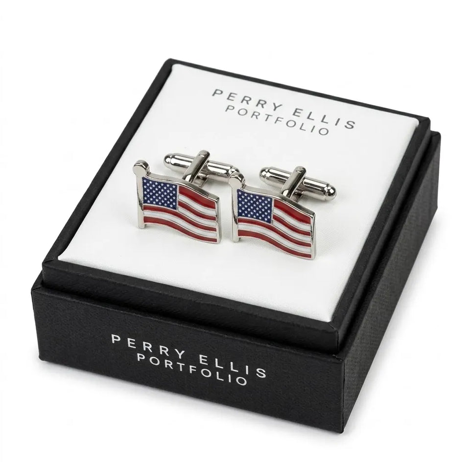A pair of silver-toned cufflinks shaped like waving American flags, displayed on a white insert inside a black Perry Ellis Portfolio gift box.