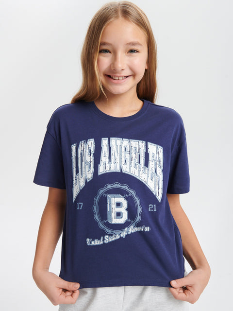 Girl wearing a navy blue t-shirt with 'Los Angeles' and 'B' logo on a white background