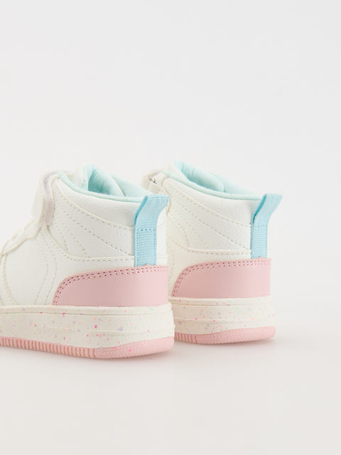 Pair of white sneakers with pink soles and blue accents on a light gray background