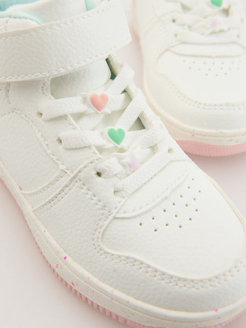White sneakers with heart designs on a light pink background