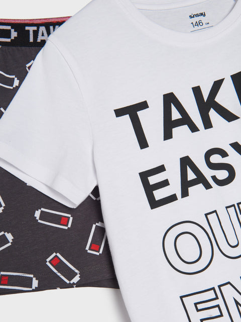 White t-shirt with 'Take It Easy On Our Engines' text, with a black underwear set in the background.