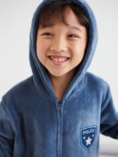 Child wearing a blue hoodie with a police emblem on a light gray background