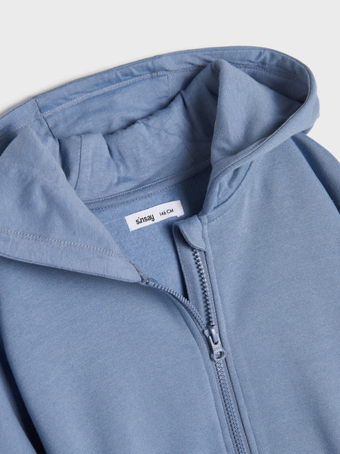 Close-up of a blue hoodie with a zipper on a light gray background