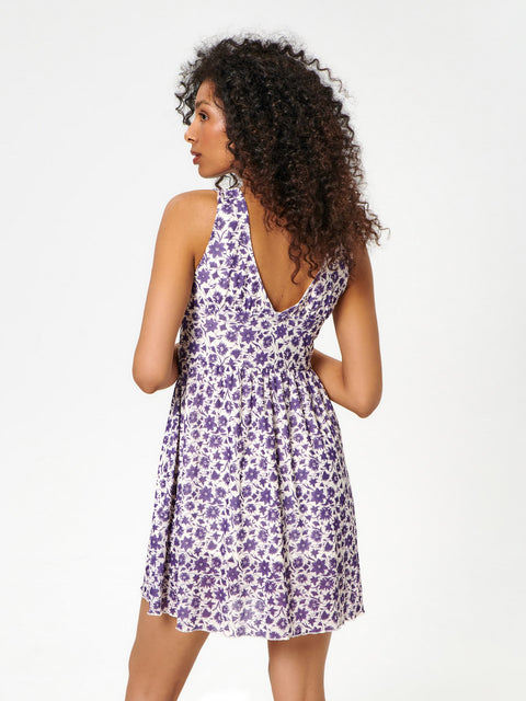 Woman wearing a purple floral dress on a white background
