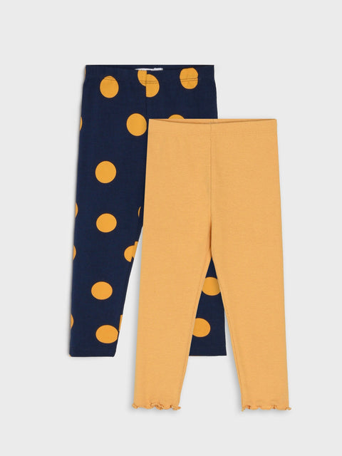Two pairs of leggings, one navy with orange polka dots and the other mustard yellow, on a light gray background.