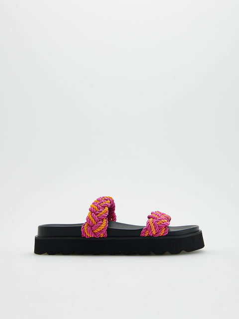 Black slide sandals with pink and purple braided straps on a white background