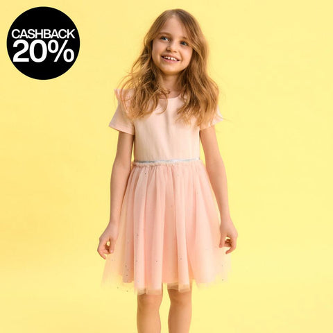 Young girl wearing a pink dress against a yellow background