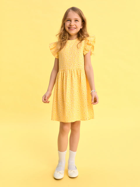 Young girl wearing a yellow dress against a yellow background